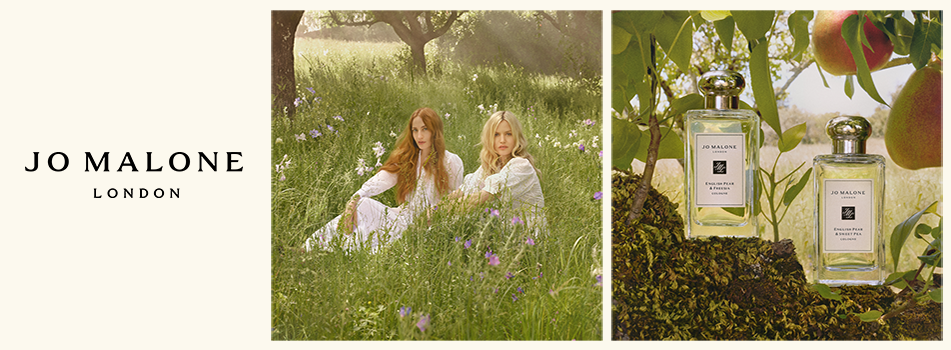 Jo Malone London Kampagnenbild mit zwei Frauen auf einer Wiese und Parfumflakons im Obstgarten